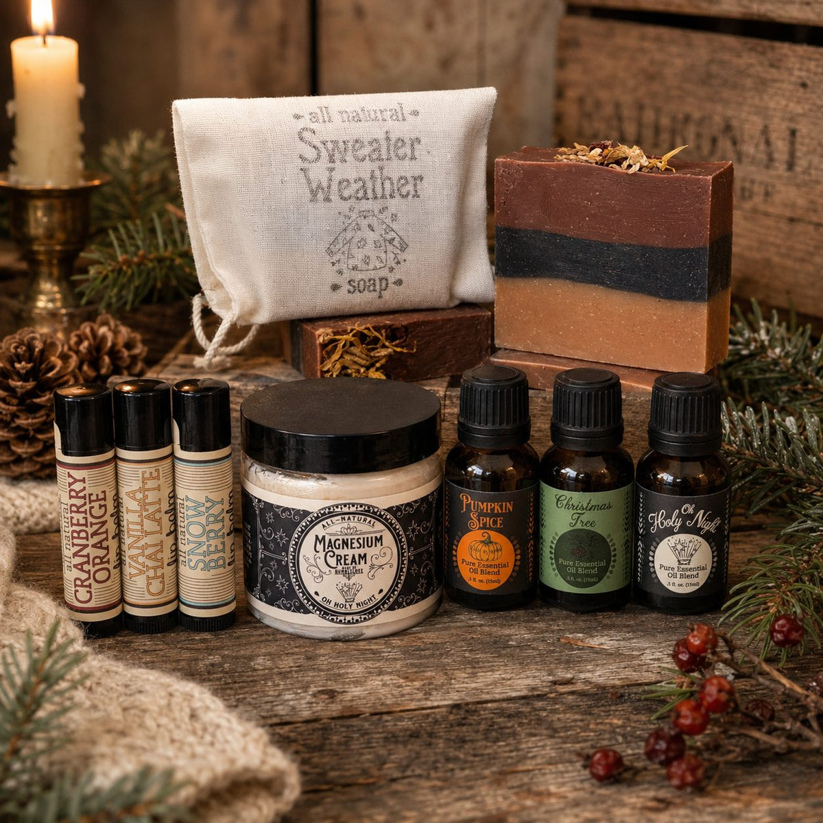 Holiday gift flat lay from The Humble Life: Sweater Weather soap bag, bar soap, lip balms, Oh Holy Night magnesium cream and essential oil blends