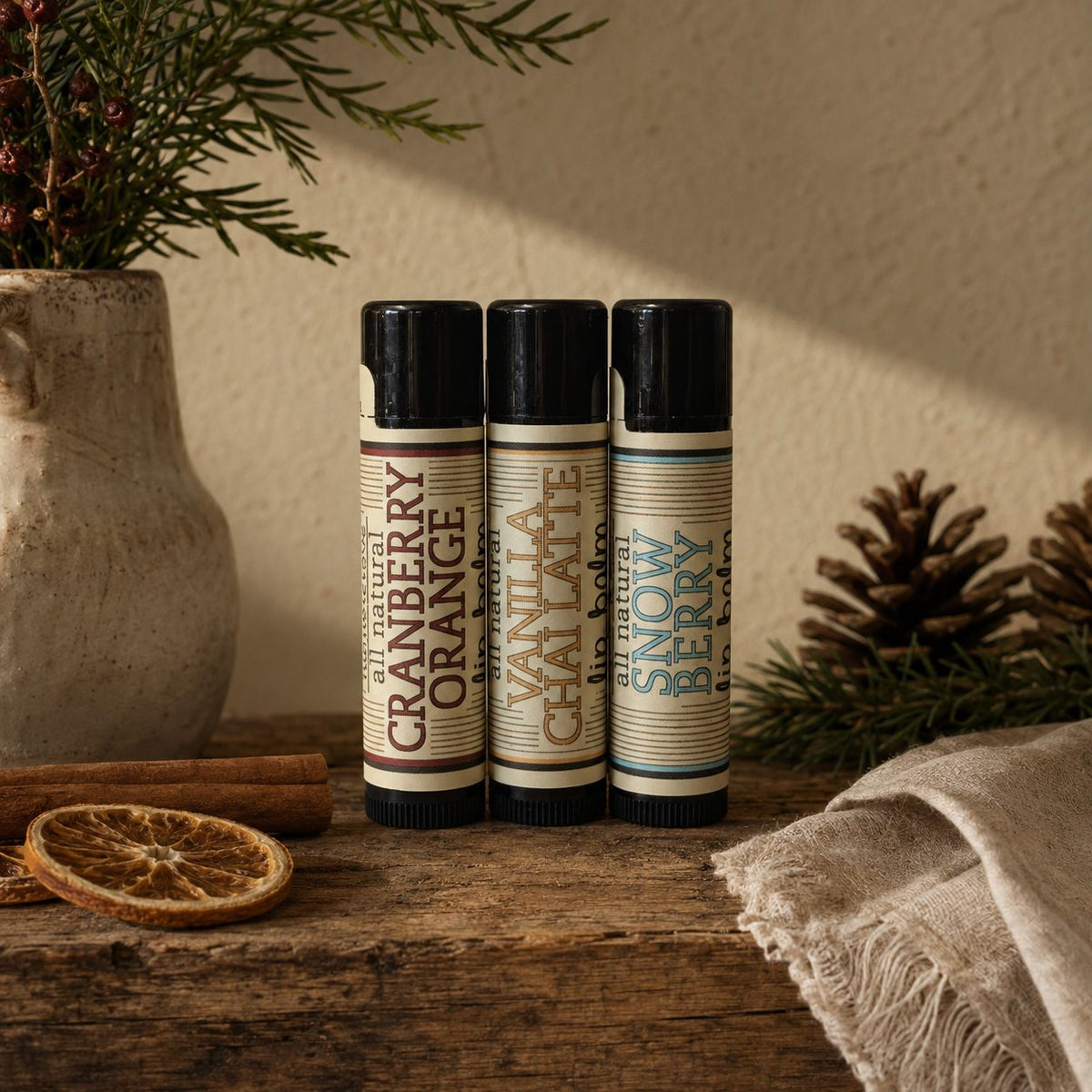 Three holiday lip balms: Cranberry Orange, Vanilla Chai Latte and Snow Berry
